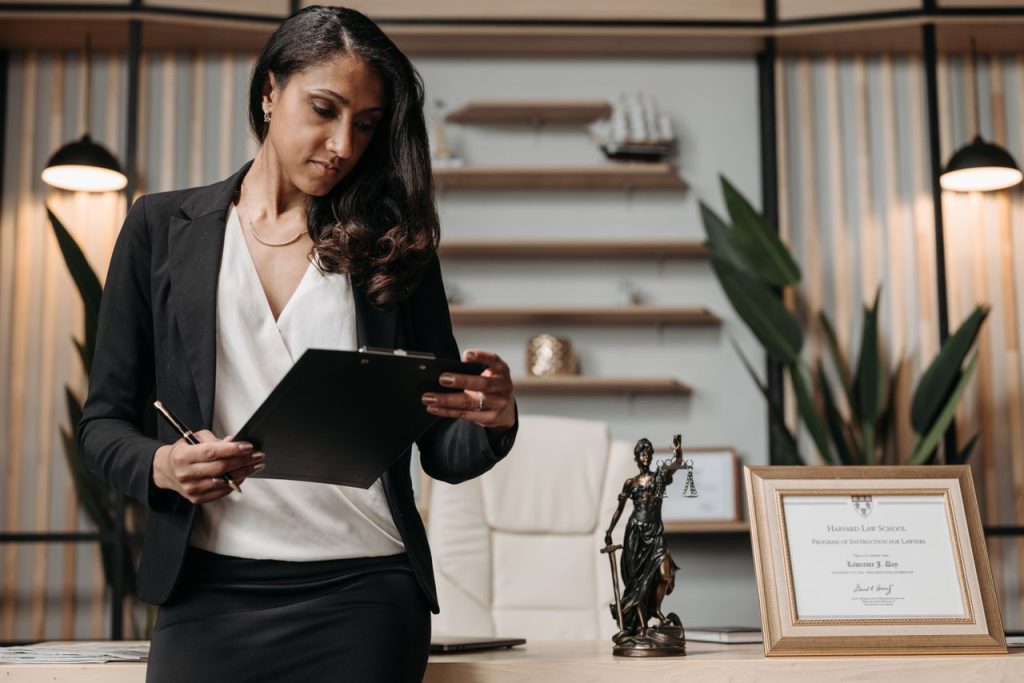 Confident businesswoman reviewing paperwork in a modern law office setting.