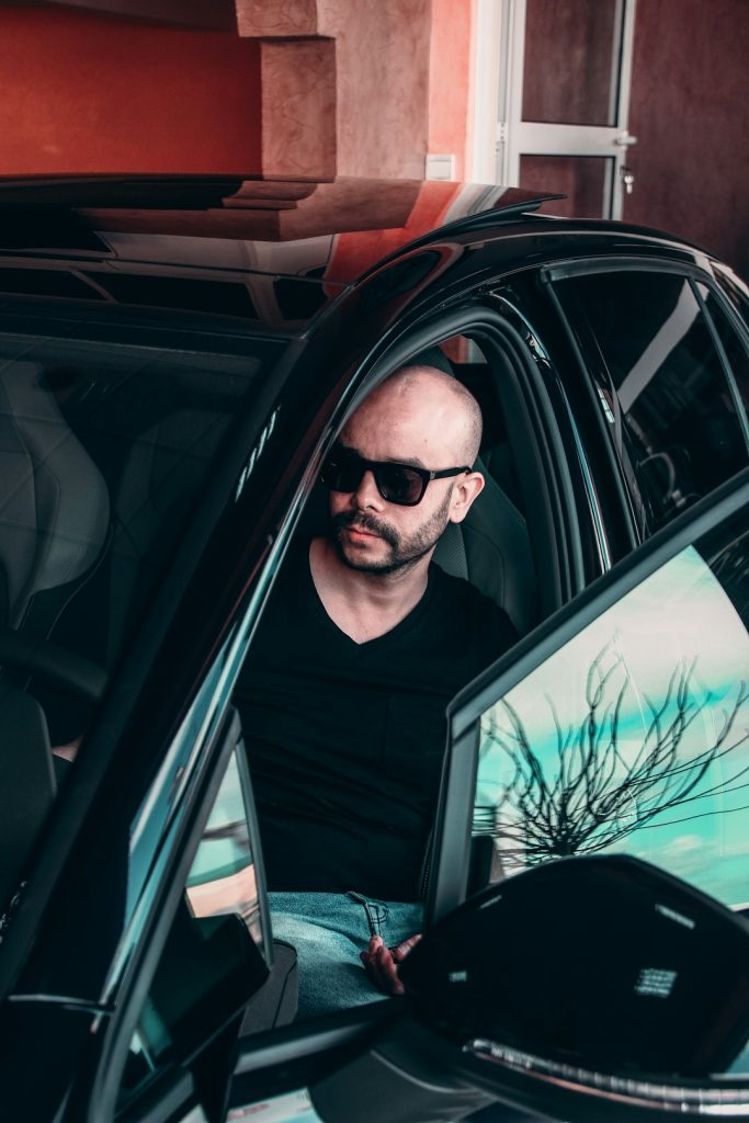 man-in-black-v-neck-shirt-wearing-black-sunglasses-inside-car-y29oish4skg